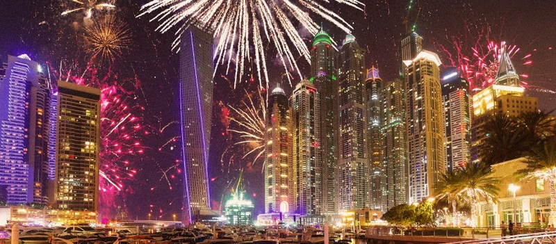 Image Description: View of Dubai’s skyline from a marina with fireworks in the background