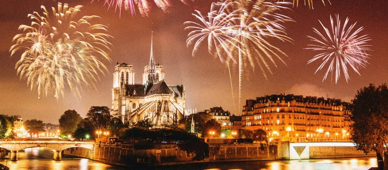 Image Description: View of the Notre-Dame Cathedral at night with fireworks in the sky