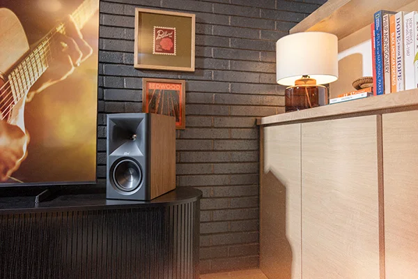 The Fives II sitting on a black side-table next to a large flat-screen TV. The Scene is set in a warmly-lit living room.