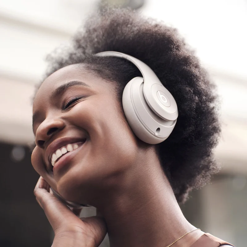 Person wearing Beats Studio Pro in Sandstone listening to music.