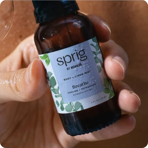 Hand holding body mist product by Sprig Kohler.