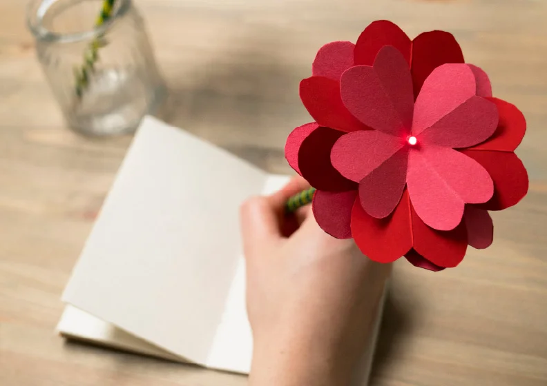 Hand holding a DIY light-up flower made from repurposed pencils.