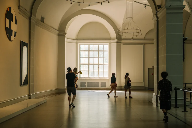 A photograph of people walking through the Beaux-Arts Court