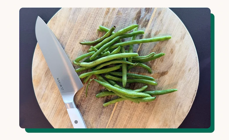 White knife ready to chop green beans.