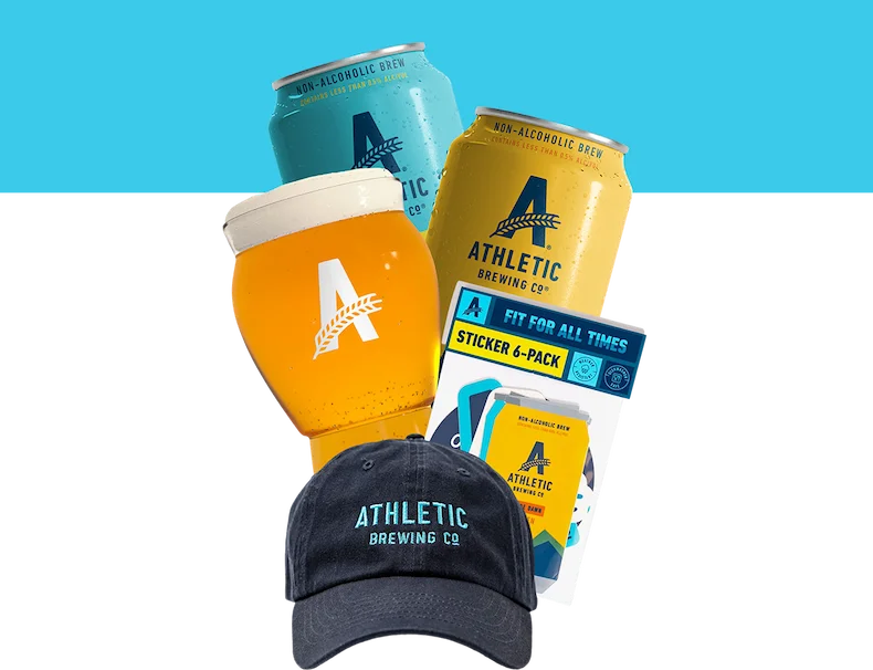 two NA beer cans, a glass, sticker pack and hat