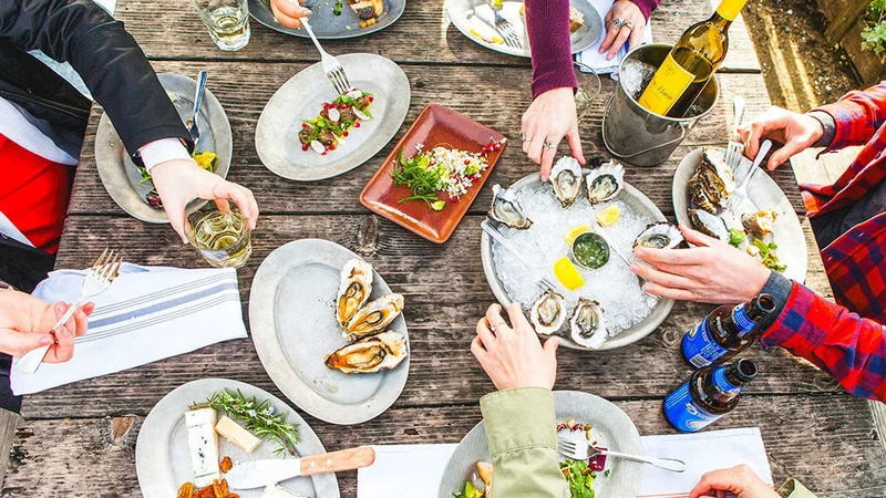 Image description: Overhead view of people eating oysters at Hog Island.