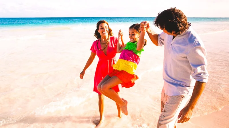 Image description: A couple playing with their daughter on a beach in Puerto Rico.