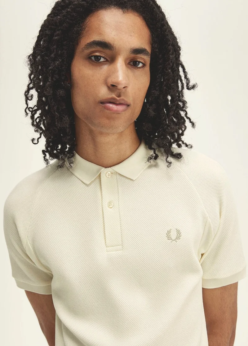 Man wearing an ecru Fred Perry Shirt