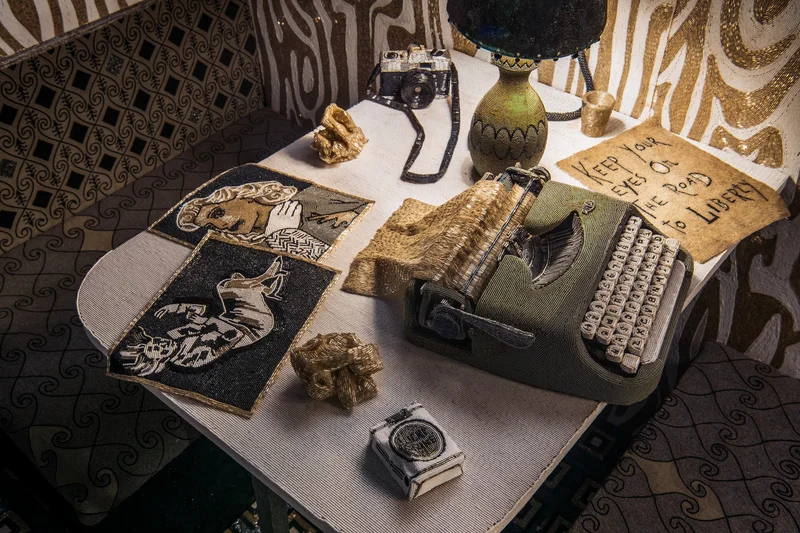 Typewriter, lamp, camera, and artworks covered in glass beads