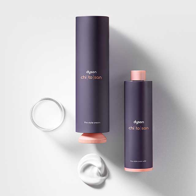 Full-size and refill bottles of Dyson Chitosan Pre-style cream in a flat-lay, with pump of product.