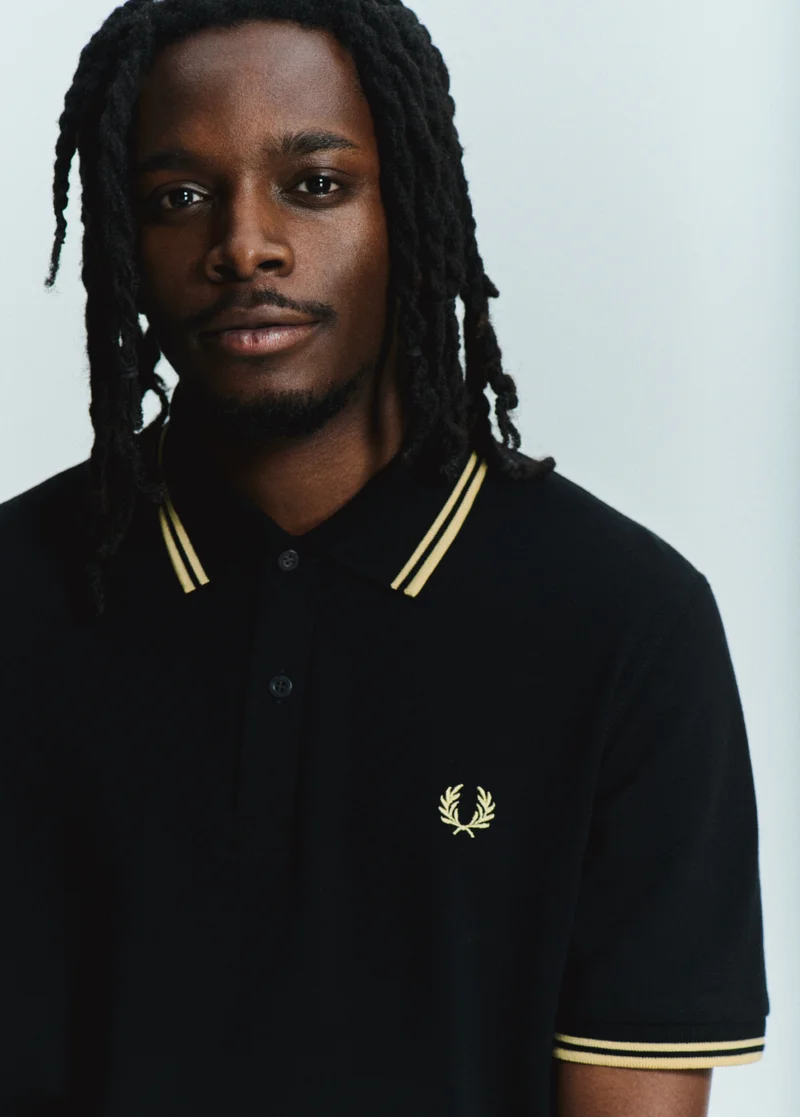 Made In England: Model wearing a Black Champagne Fred Perry Shirt