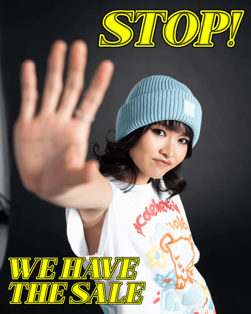 stop! we have the same [image of a young woman holding out her hand in a 'stop' gesture, wearing a blue beanie and a white shirt with illustration on it]