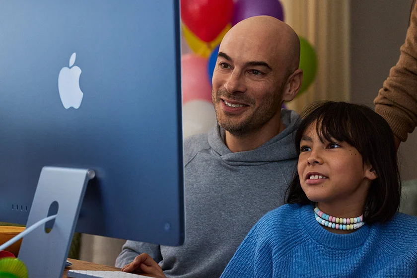 Parents and child view an iMac in Blue