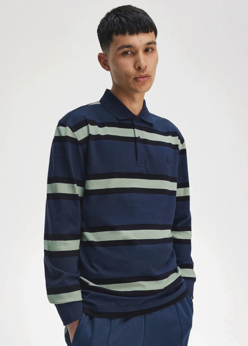 Male model wears long sleeved dark blue polo with thin mint green and black stripes