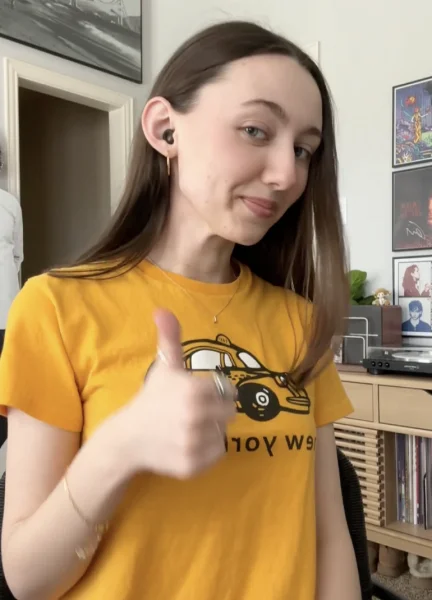 A woman wearing Loop Quiet earplugs gives a ‘thumbs-up’ gesture.