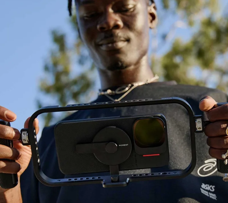 Image of someone holding a filmmaker cage with an iphone in it and the new moment quick lock filter.