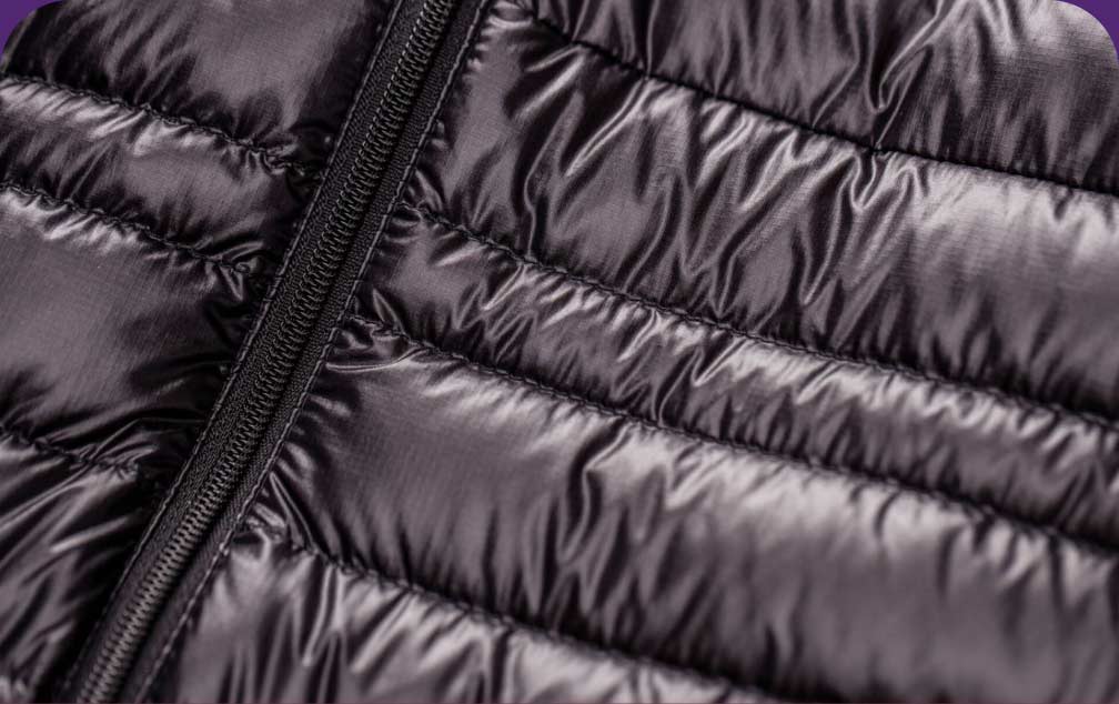 Magnified image of the baffles on a black puffy jacket.