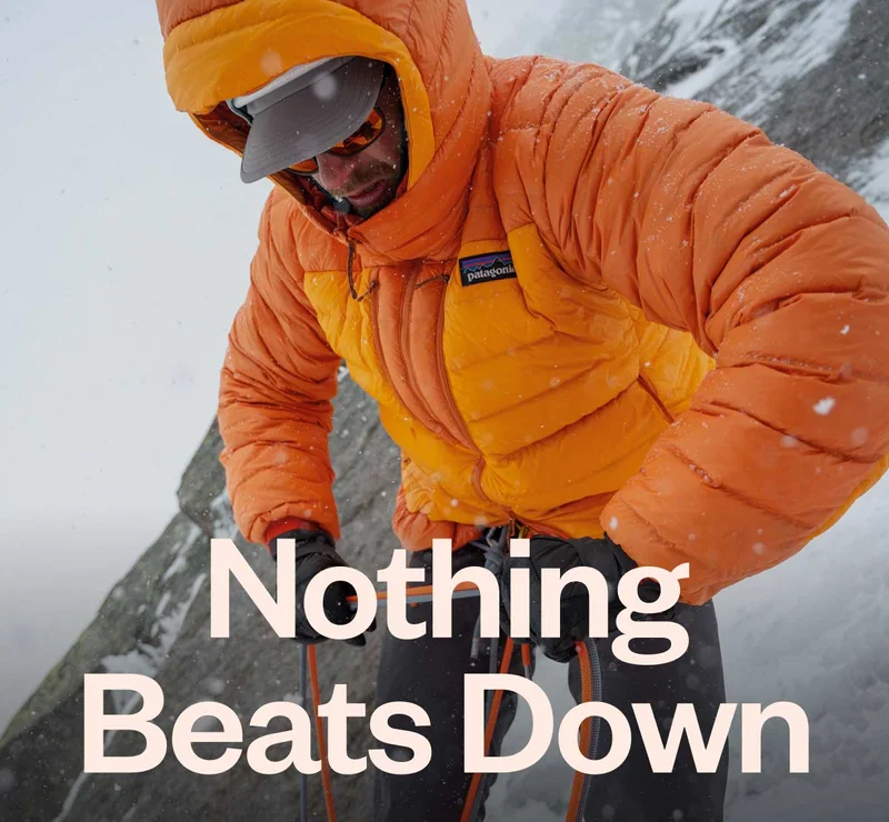 Nothing beats down. A climber in a thick puffy jacket coils rope on a snow-covered mountain.