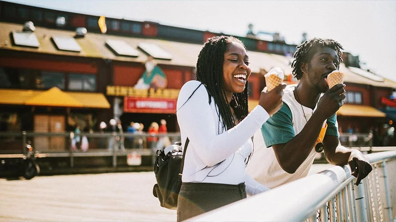 Image description: Two friends eating ice cream on a pier in Seattle.