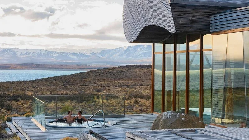 Image description: A couple sits in a hot tub at Tierra Patagonia in Torres del Paine National Park, Chile.