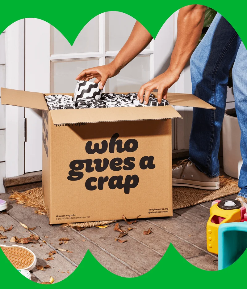 Image: Dad opening a box of Who Gives A Crap 100% Bamboo Toilet Paper.