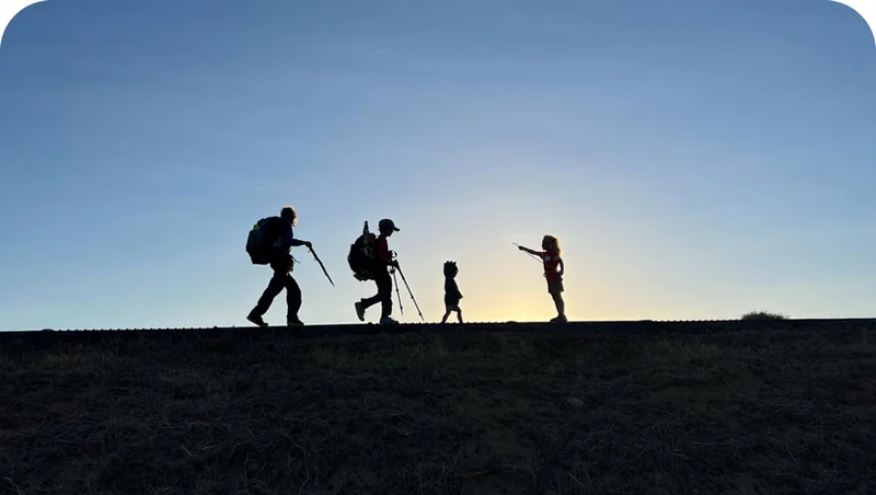 Silhouette of four people with backpacking gear.