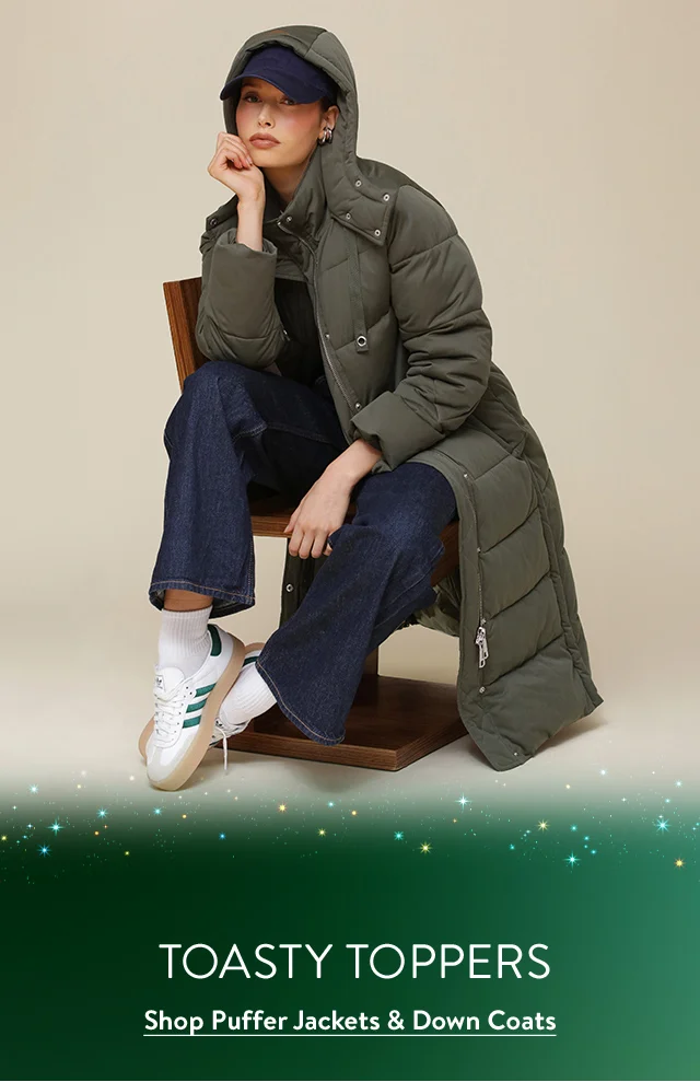 A woman wearing a long taupe puffy coat.