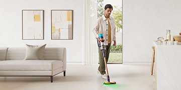 A man using a Dyson cordless vacuum in handheld mode