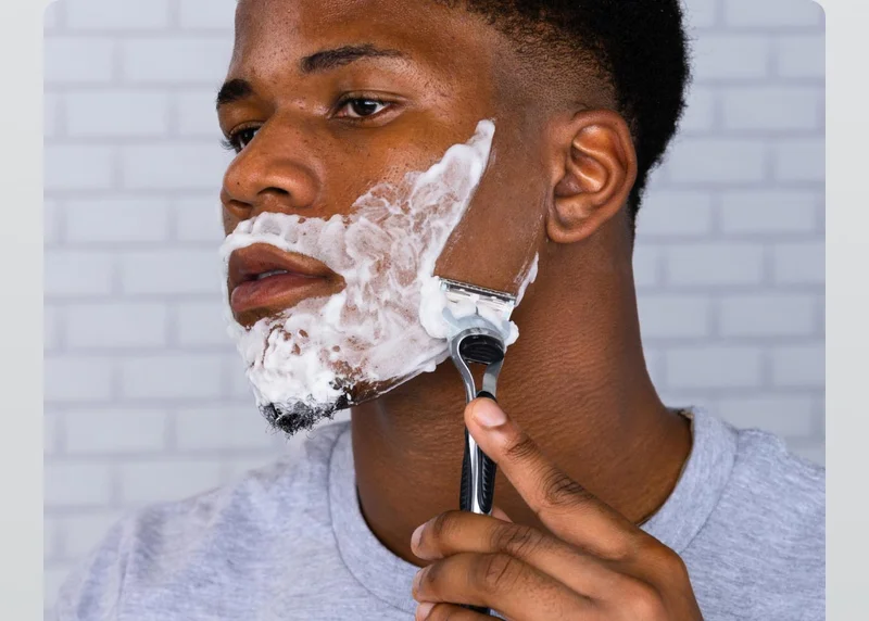 Young man shaving his face with SkinGuard razor