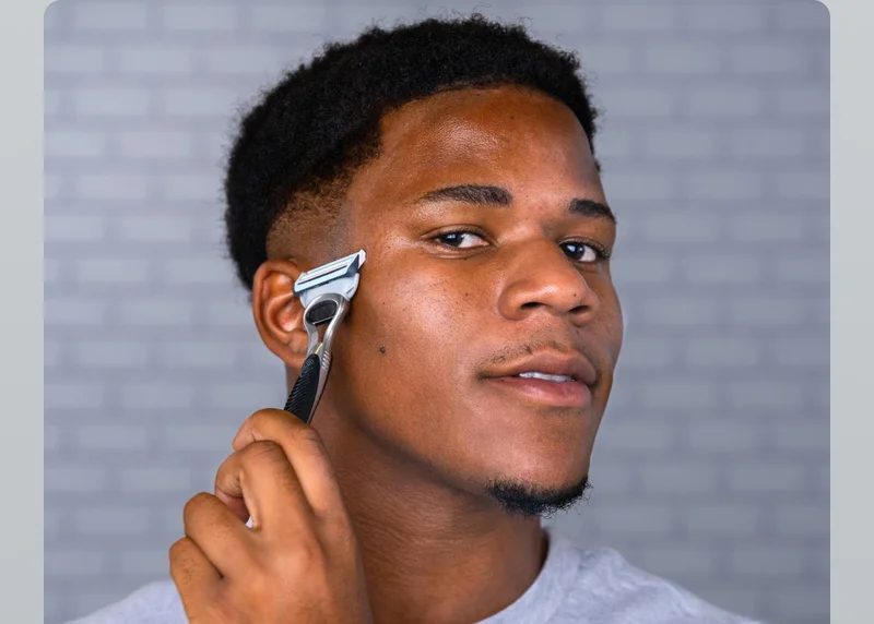 Young man trimming his sideburn with SkinGuard trimmer