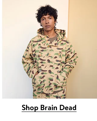 A man wearing a camo jacket and pants from Brain Dead.