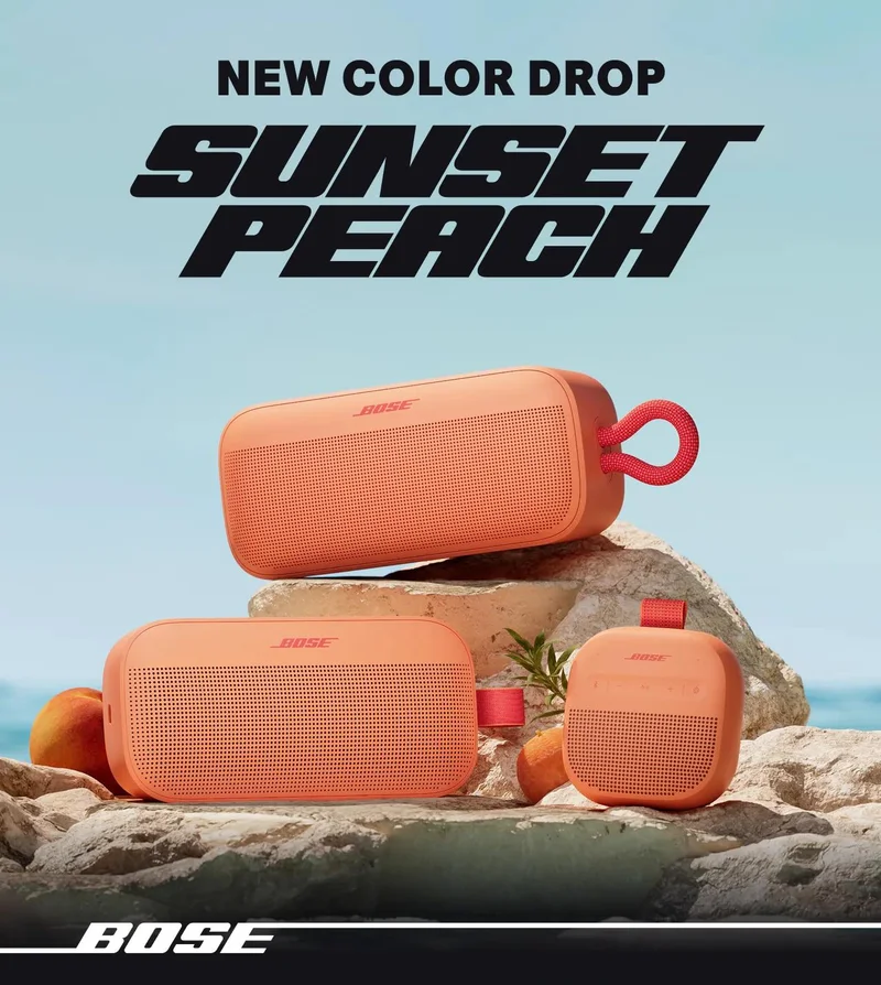 SoundLink Plus, SoundLink Flex (2nd Gen), and SoundLink Micro (2nd Gen) portable speakers in Sunset Peach on a beach