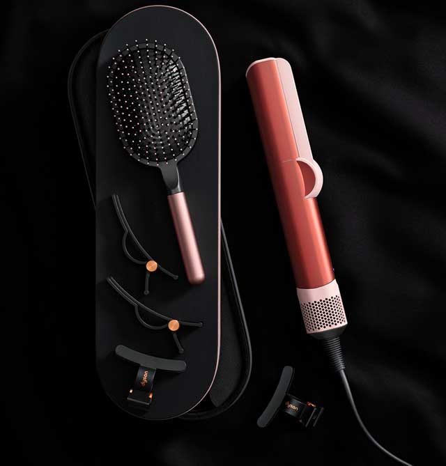 Dyson Airstrait straightener and accessories in Strawberry bronze and blush pink.