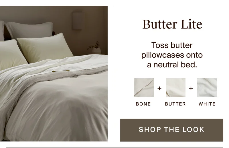 Butter pillowcases on a neutral bed of bone and white sheeting. Shop the look