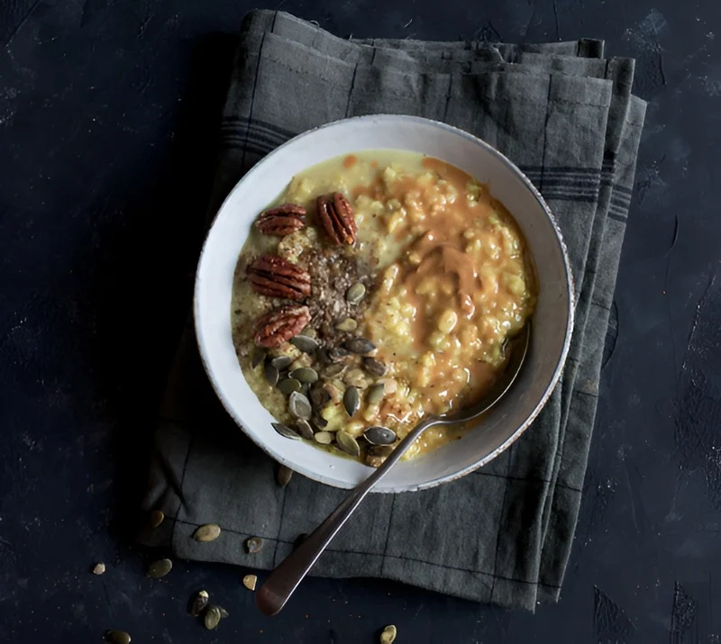 A bowl of oatmeal with nuts and seeds
