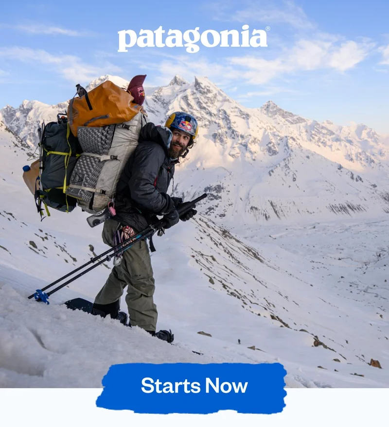 Patagonia. A snowboarder with a very heavy pack looks back over his shoulder before the descent.