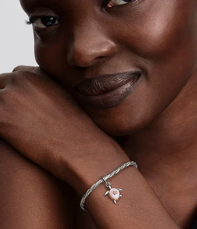 The turtle charm styled on a snake chain bracelet