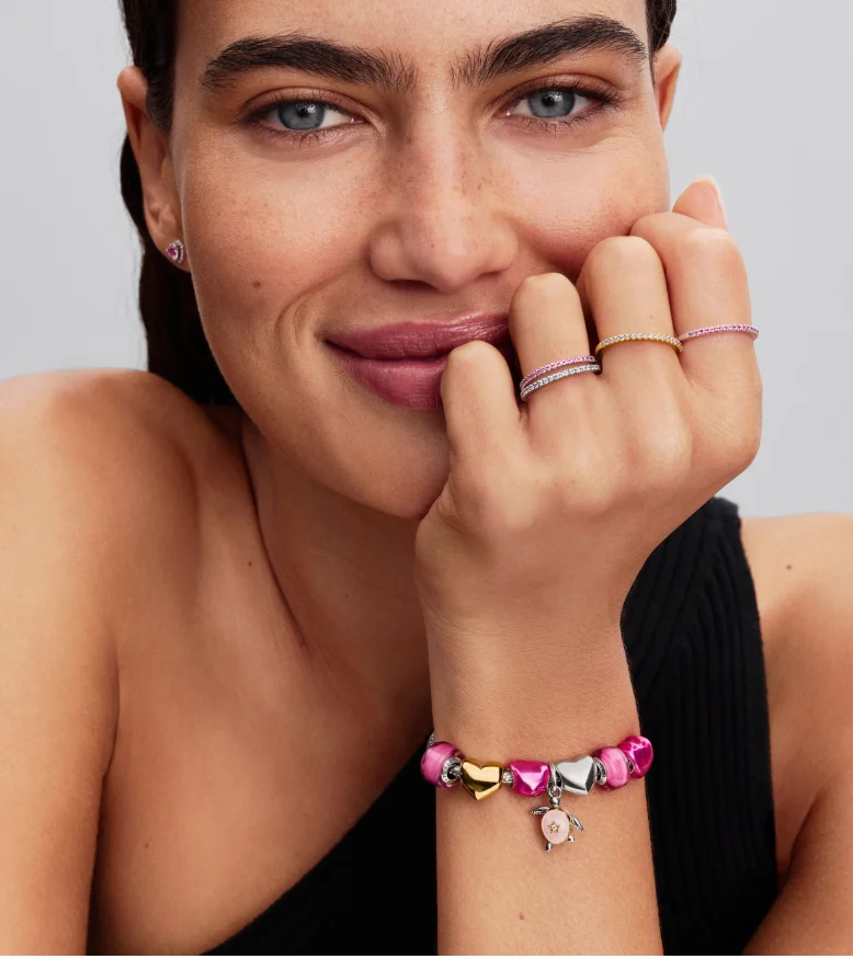 Model wearing a tonal pink styling, featuring the turtle charm