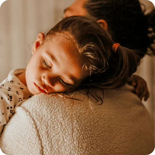 a little girl sleeping on mom's shoulder for daylight savings time tips a little girl sleeping on mom's shoulder for daylight savings time tips