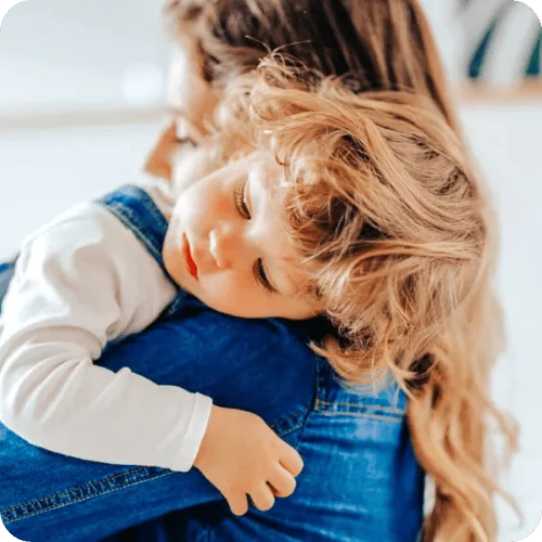 a toddler resting their head on their mom's shoulder a toddler resting their head on their mom's shoulder