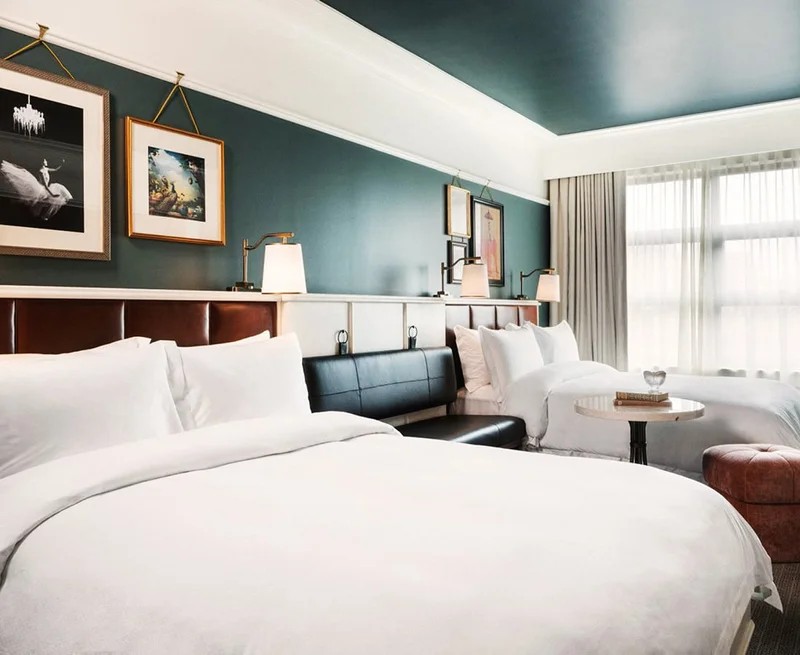 Image Description: Two double beds in a green and white hotel room.