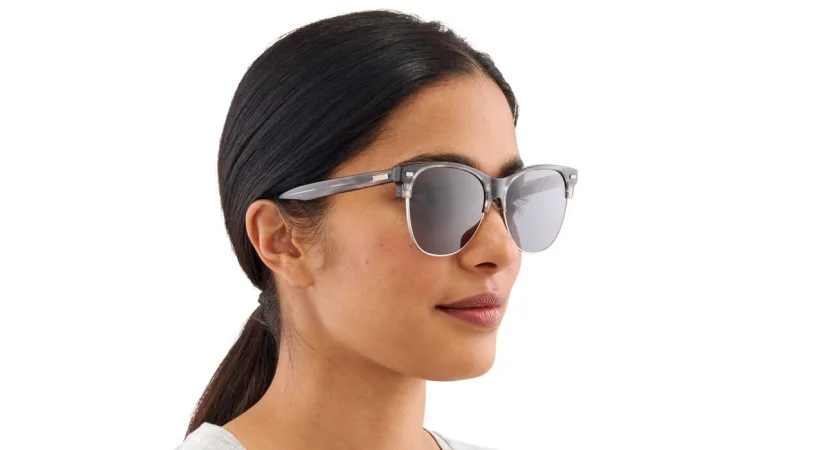 Close-up shot of a female model wearing the Anon Promoter Sunglasses in Pink SLT looking at the distant mountains