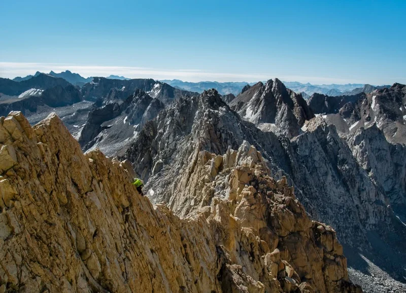 A climber traverses a jagged ridgeline.