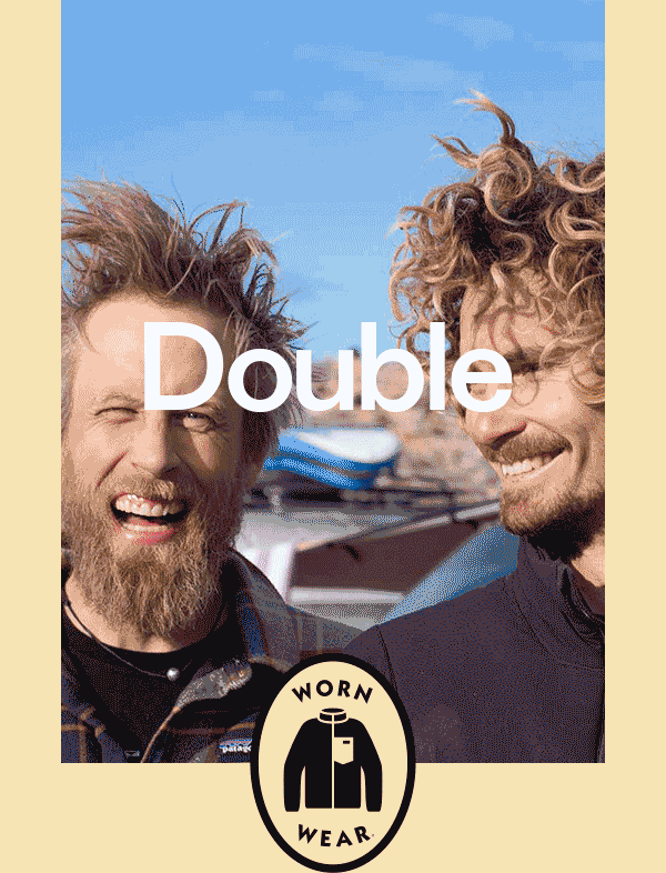 Patagonia. Two people smile in front of a car with surfboards strapped to the roof.