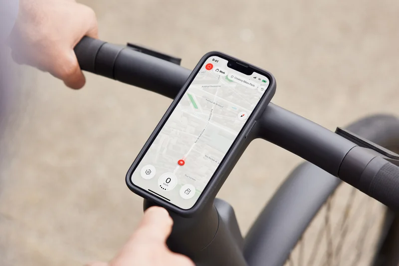 A photograph of a smart phone displaying the Cowboy app, mounted to the bike Cockpit