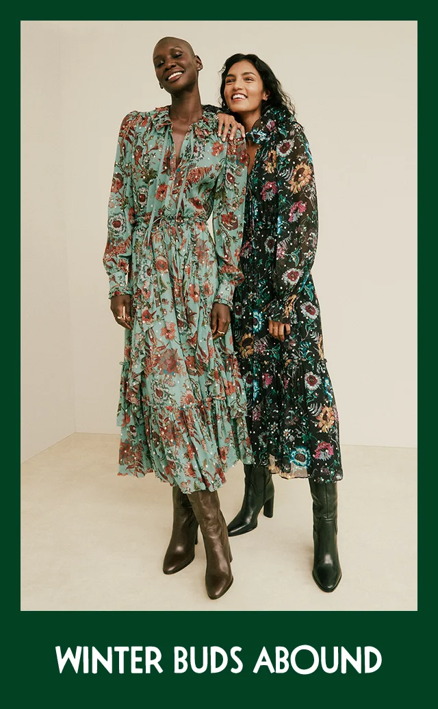 Two women wearing floral-print midi dresses with boots.