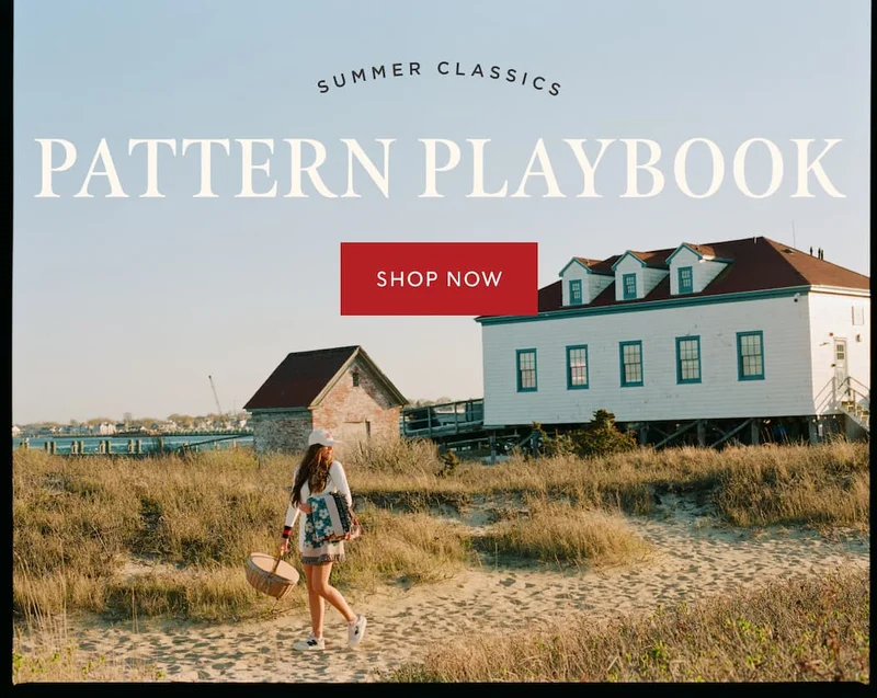Woman walking near beach houses, with text that reads "Summer Classics: Pattern Playbook" and a red button labeled "Shop Now."