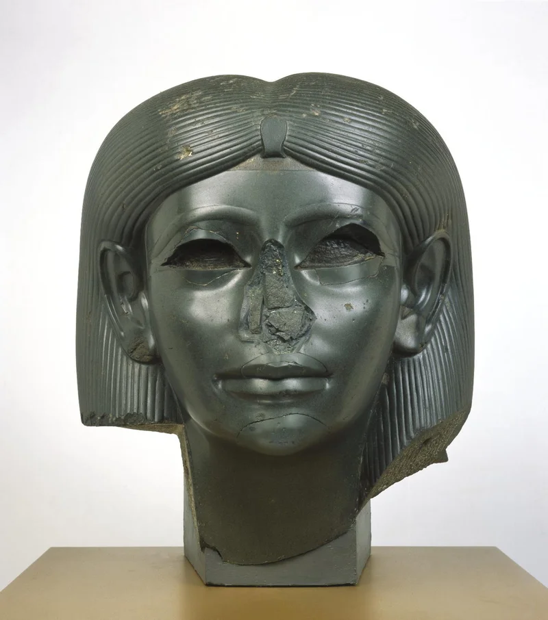 Green female sphinx head with a damaged nose