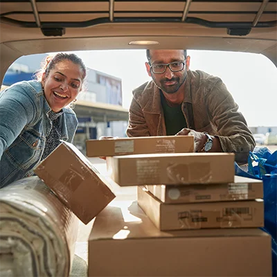 People putting boxes into car