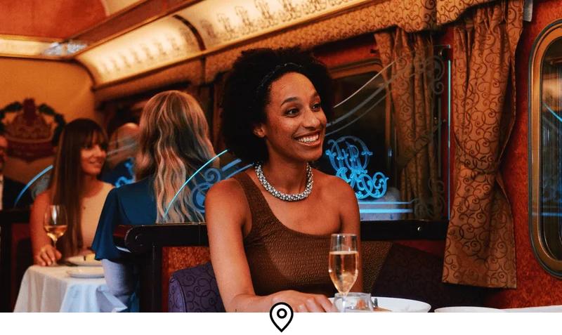 Image description: A woman sitting inside the dining car of The Ghan